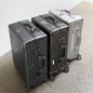 Preview: Two space grey GUNDEL suitcases with a line pattern standing in a field with dry grass.